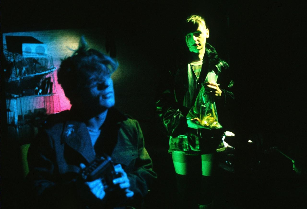 Official Decoder film still showing two characters under blue and green lighting