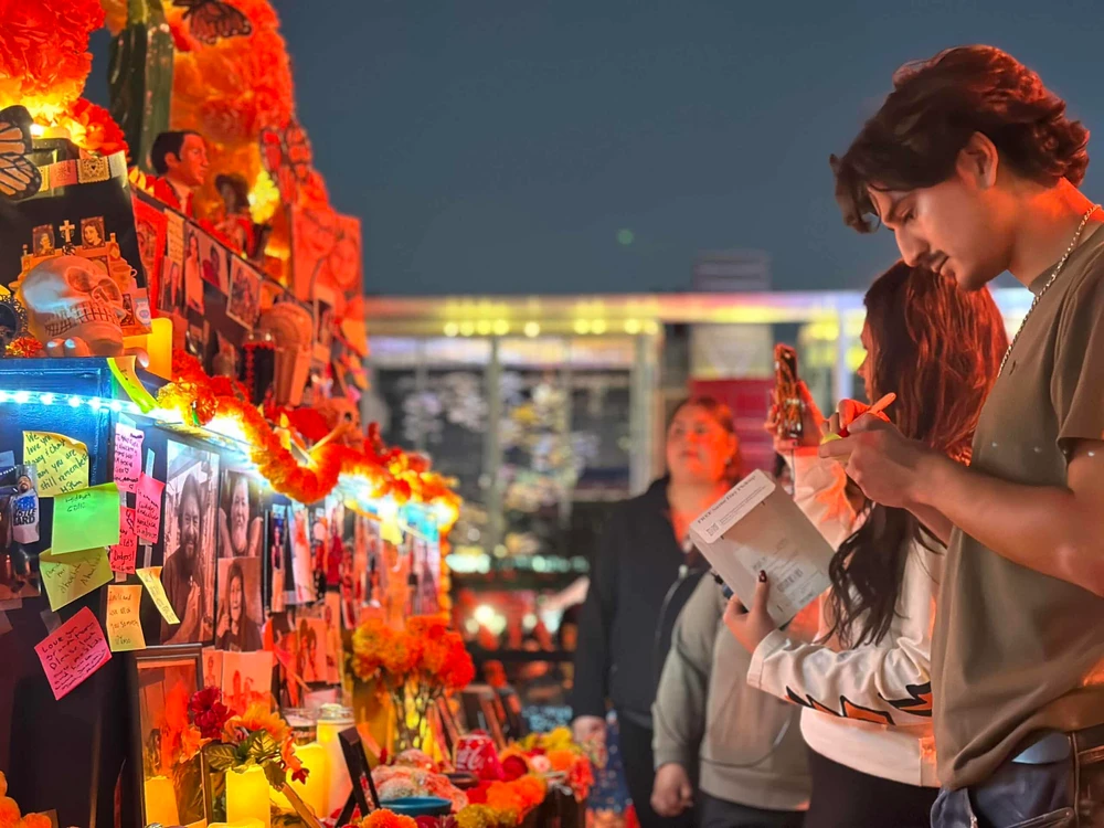 Archival photograph from Discovery Green’s official Día de los Muertos page, showing visitors at an ofrenda; not a 2026 event photo.