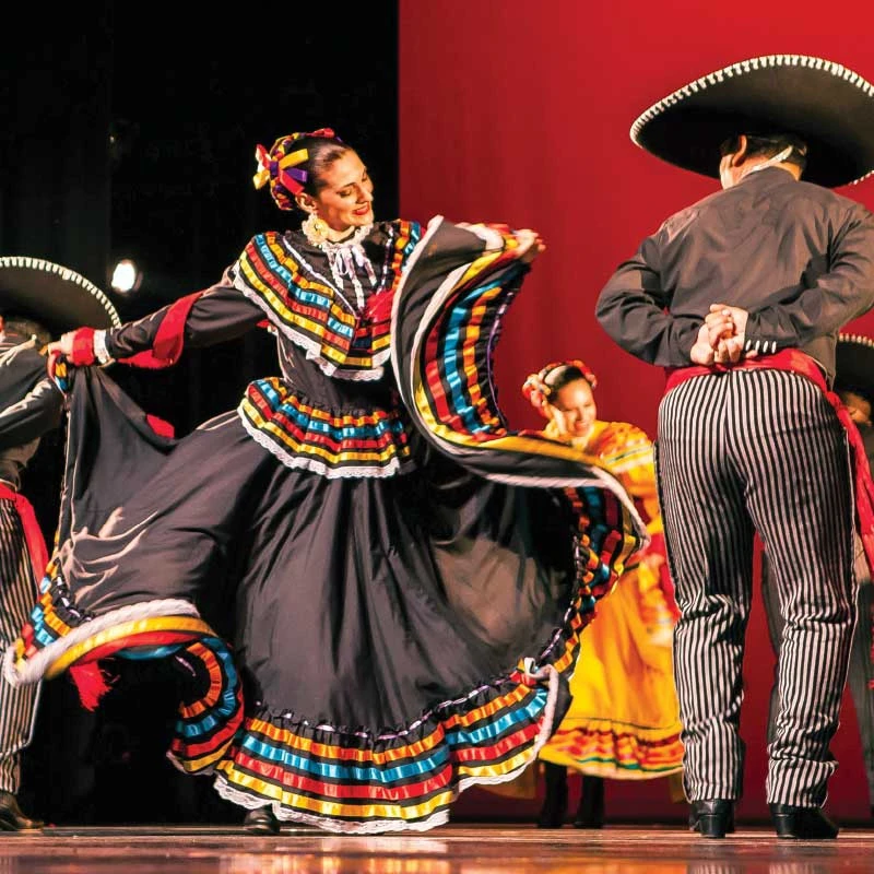 Official venue photograph of Mixteco Ballet Folklorico dancers in colorful Mexican regional costumes.